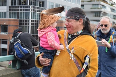A man shares a moment with his young daughter as they march across Vancouver's C