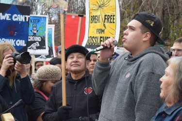 Cedar George-Parker (centre), a youth from Tsleil-Waututh Nation, speaks to a cr