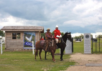 Horse riders Marcell Perrin and Vern Brewster pose in front of the new gate that