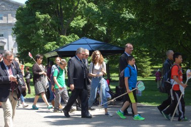 A youth plants a heart in the garden of hearts at Rideau Hall